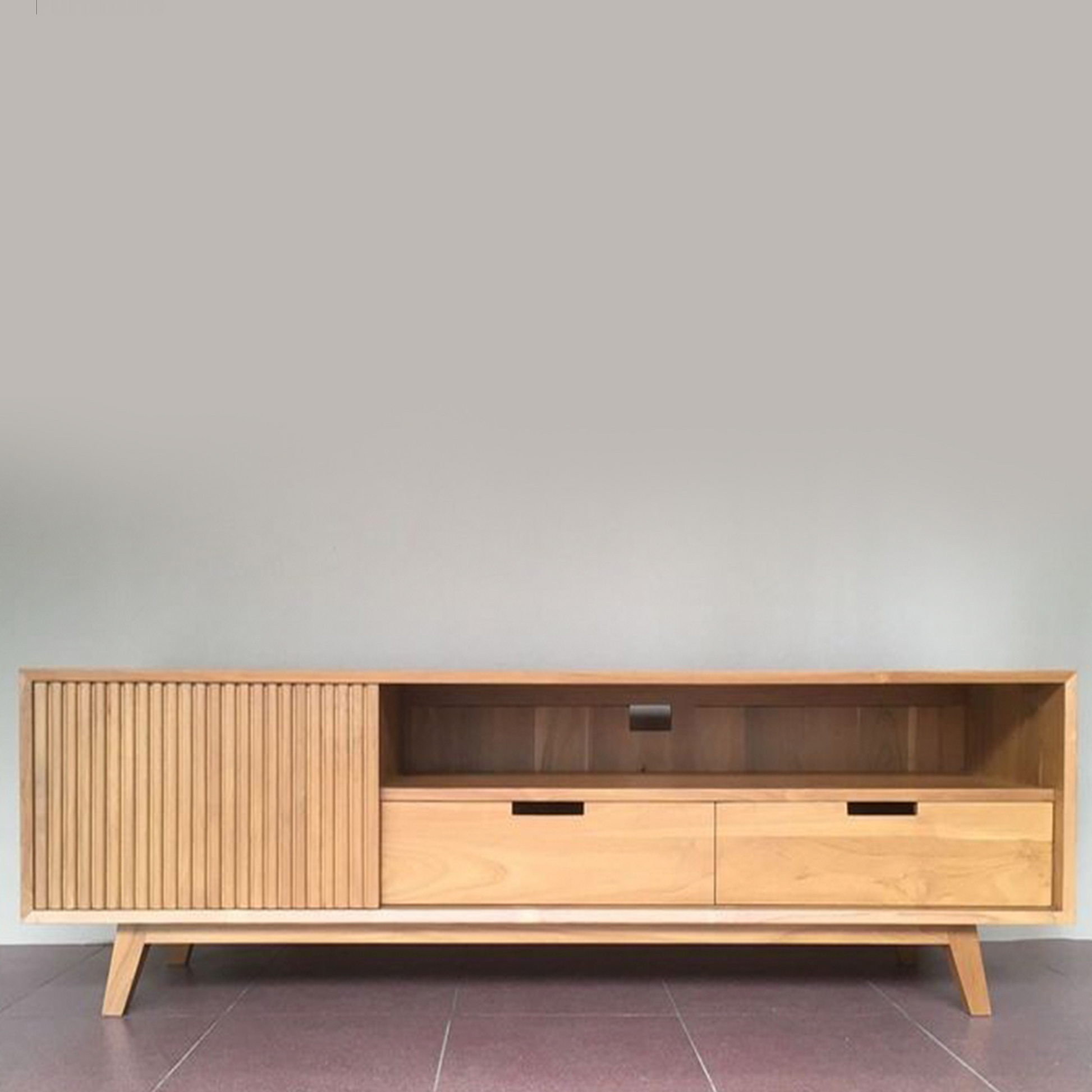A light natural wood TV stand or media console with slatted cabinet doors, two drawers, and open shelving, shown in a styled living room setting with a wall-mounted TV, bowl, and rug.
